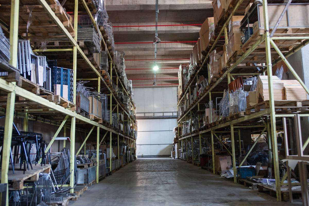 Depósito con estanterías cargadas: paletas de madera y mercadería de distinto tipo y tamaño en cada nivel